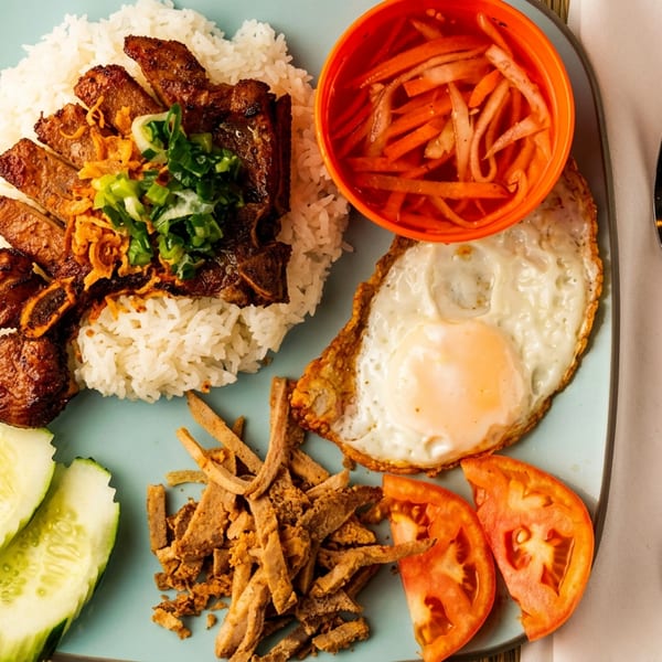 Com Tam, a Vietnamese broken rice dish with grilled pork, fried egg, and pickled vegetables.